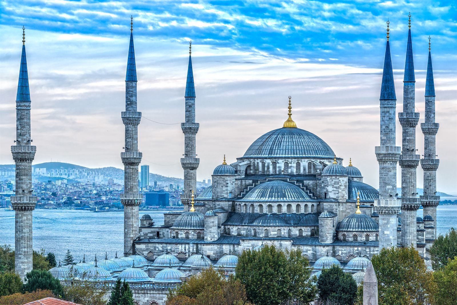 The Blue Mosque in Istanbul with its domes and six minarets, the water and city beyond