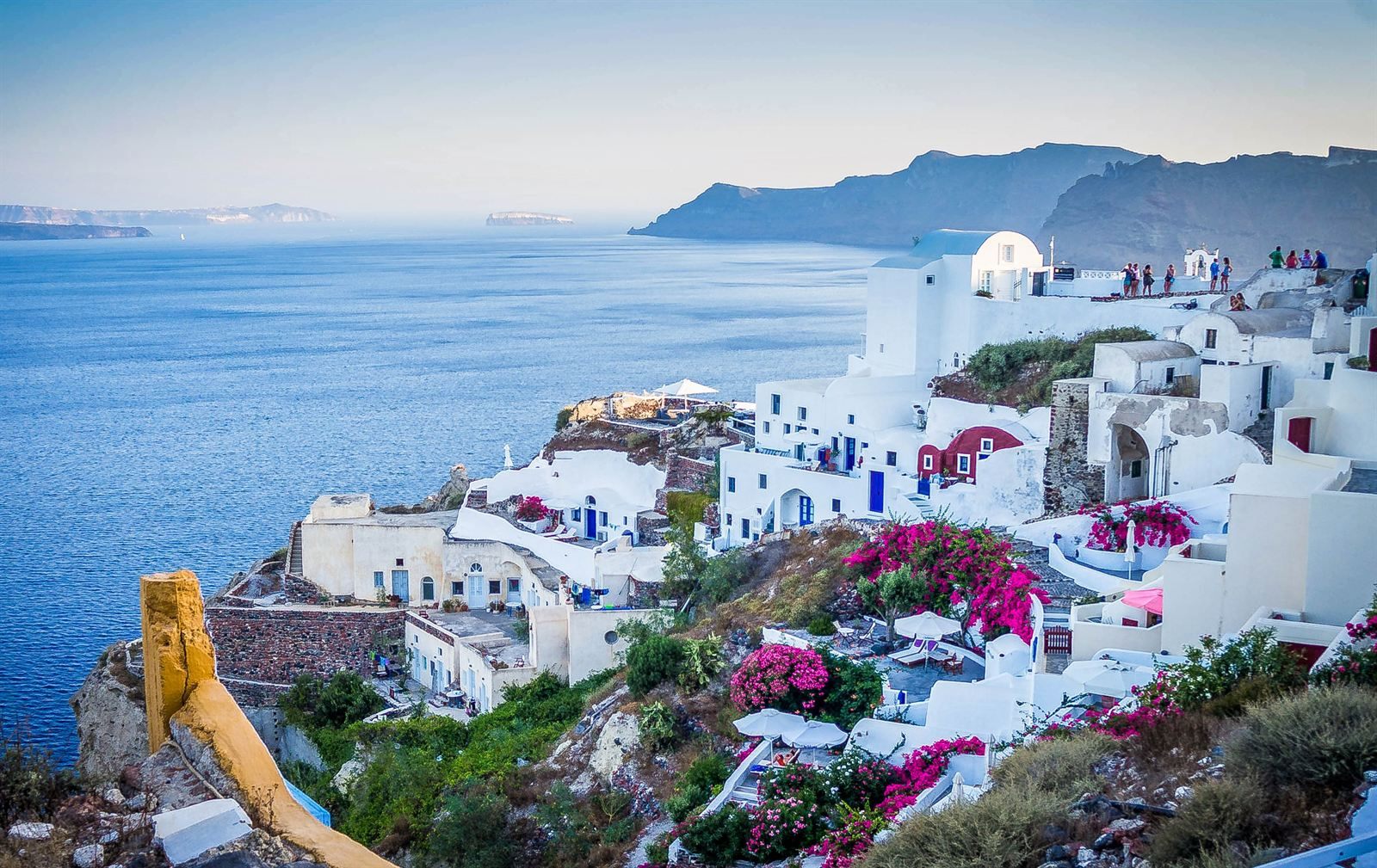 White cliffside houses and pink bougainvillea in Oia overlooking the Santorini caldera